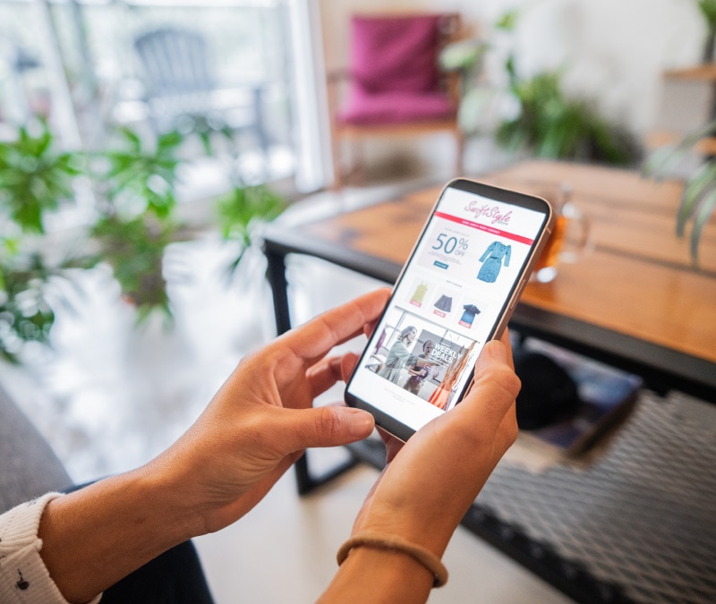 Abbildung: Hände, die ein Smartphone mit einer potenziell schädlichen Werbeanzeige halten