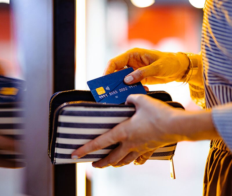 Bild von jemandem, der eine Karte aus einer möglicherweise RFID-blockierenden Tasche herauszieht.