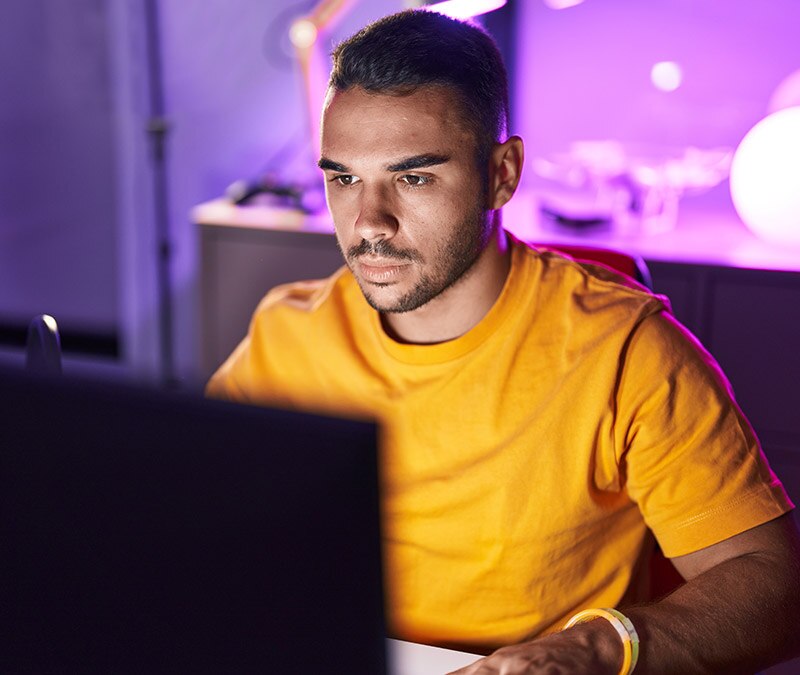 Ein Mann am Laptop, der recherchiert, was der Tor-Browser ist und wie man darüber ins Darknet gelangt.
